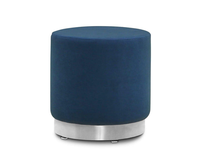 The Isla Ottoman, featuring a round silhouette and smooth blue velvet upholstery, is displayed against a white background.