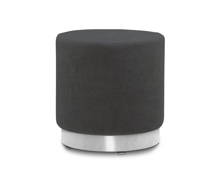 A round, dark grey Isla Ottoman with smooth velvet upholstery and a striking brass base, set against a plain white background.