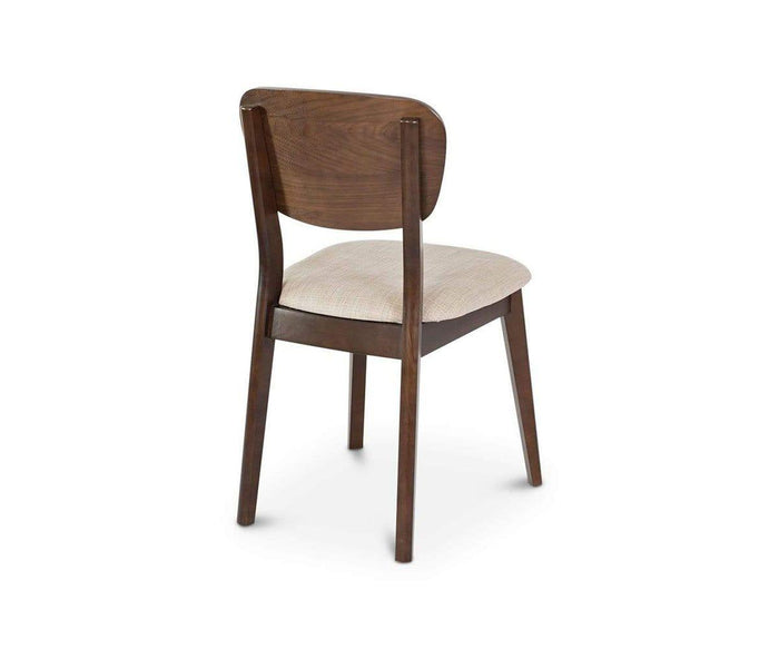 The Juneau Dining Chair is shown at an angle against a white background, showcasing its simple, modern design with a curved wooden backrest, cushioned cream fabric seat, and elegant walnut veneer.