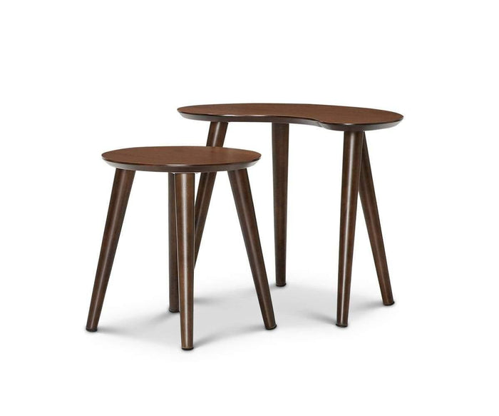 The Juneau Nest Of Tables showcases two dark wooden side tables, each with three legs—the shorter one features a round top while the taller table displays an irregular kidney-shaped surface. With a subtle mid-century modern flair and set against a plain white background, the Juneau Nest Of Tables offers a timeless addition to any living space.