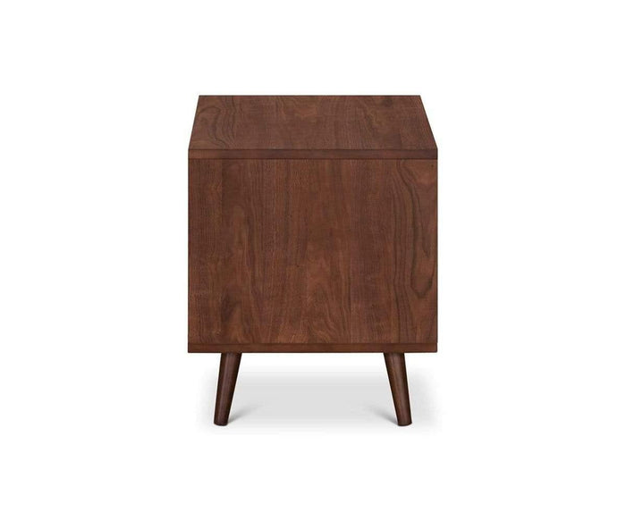 The Juneau Nightstand showcases a mid-century modern design with a rectangular wooden top and four angled legs, making it perfect as a single drawer nightstand. Shown from the side against a white background, this stylish piece of bedroom furniture blends timeless appeal with practical function, enhancing any room with its elegant look.