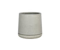 A simple, light grey, cylindrical Kamden Planter featuring a slightly wider bottom edge is shown against a white background. This lightweight fiberstone planter offers a blend of modern simplicity and durability.
