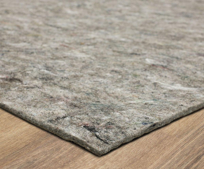 A close-up view of the Karastan Rug Pad in gray felt, featuring a slightly mottled texture and placed on a light wood floor for reliable rug protection.