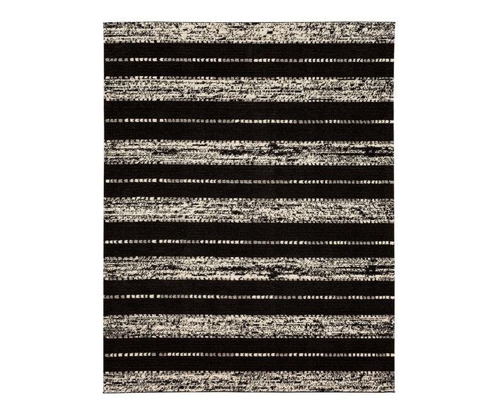 Introducing the Karastan Traverse Lanes Rug - Charcoal, a rectangular modern rug featuring alternating black and white horizontal stripes. The textured, uneven pattern of the stripes creates a contemporary, abstract aesthetic against a plain white background. Crafted from durable polyester in black, this rug is ideal for high-traffic areas.