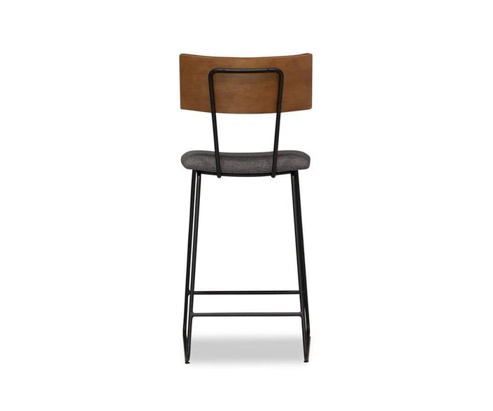 A back view of the Karsten Counter Stool with Back highlights its wooden backrest crafted from live edge wood for a natural, organic feel, complemented by a padded gray seat and sturdy black metal legs, all set against a plain white background to emphasize its rustic industrial style.