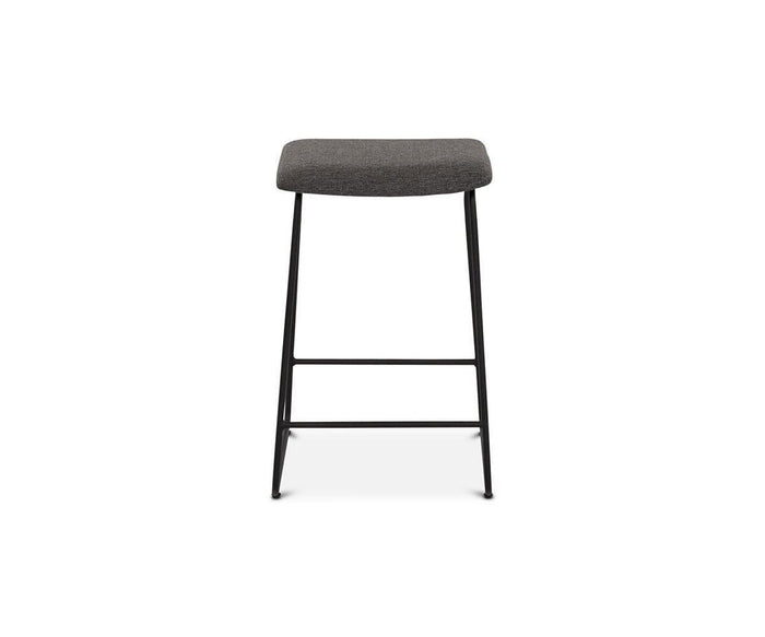 The Karsten Counter Stool showcases a modern rustic industrial design with a rectangular grey cushioned seat and sleek black metal legs, displayed from the front against a white background.