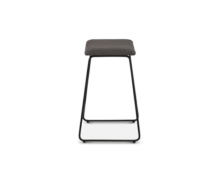 The Karsten Counter Stool features a modern rustic industrial design with a rectangular, dark cushioned seat and a black metal frame, displayed from the front against a white background.