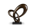 Introducing the Kinetic Current Sculpture in dark brown resin—a striking abstract piece composed of two interlocking loops on a sleek black rectangular base, set against a plain white background. This modern sculpture embodies fluid movement and contemporary elegance, making it a perfect addition to any space.