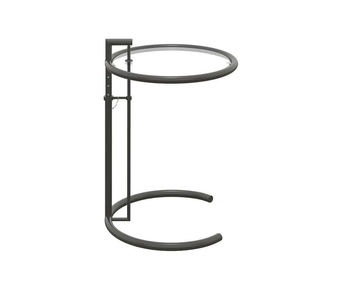 The Krom C-Table, shown against a white background, features a clear glass circular top and a curved black metal base with adjustable height for a sleek, minimalist look.