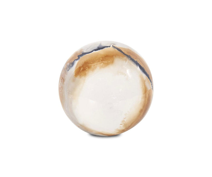 The Lahar Iron Sphere features a smooth, polished finish accented by swirling white, brown, and black patterns that mimic the look of natural stone or agate. Its volcanic-inspired design stands out beautifully against a plain white background.