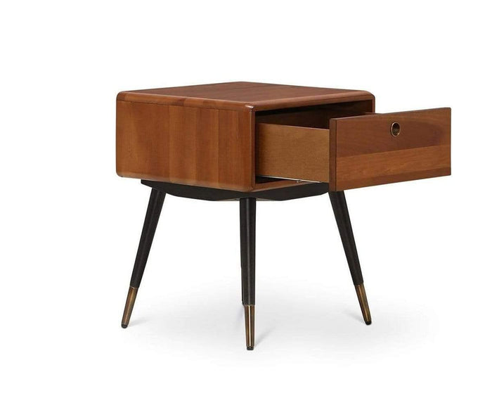 The Lanson Nightstand is a mid-century modern piece crafted from walnut, featuring a single open drawer and angled black legs with gold tips, pictured against a white background.