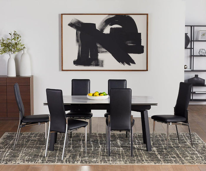 Modern dining room with a rectangular table, six Lykke High Back Dining Chairs offering padded comfort, a bowl of fruit, abstract black-and-white artwork on the wall, and vases with greenery on a sideboard. Geometric-patterned rug covers the wooden floor.