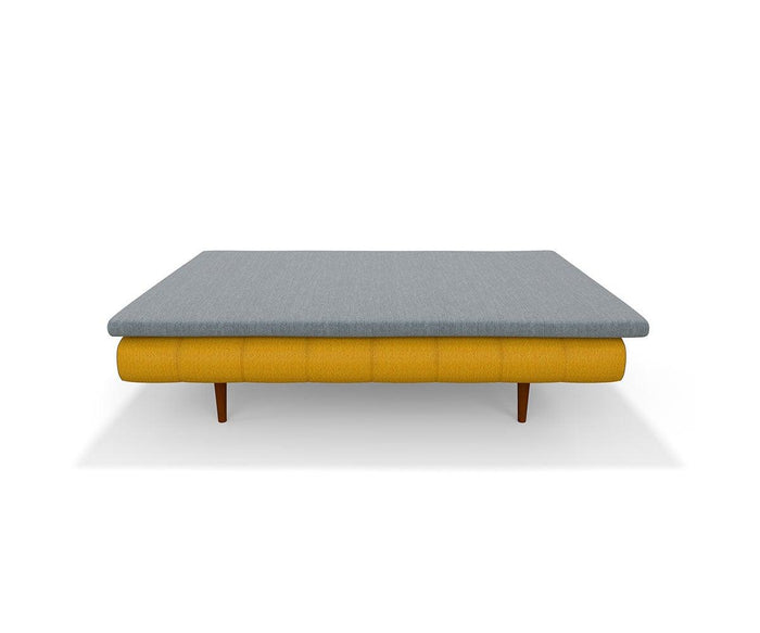 Mattress Topper displayed on a modern sleeper sofa with a yellow cushioned base, wooden legs, and a flat, gray fabric top—ideal for adding extra comfort—shown against a plain white background.