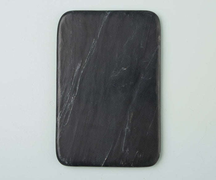 The Mirco Black Marble Slab, a rectangular black marble cutting board with rounded corners and subtle white streaks that mimic a handcrafted aesthetic, is displayed on a light gray surface.