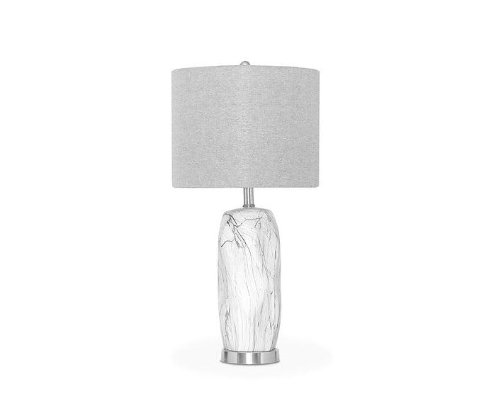 The Nemling Table Lamp features a modern design with a light gray linen drum shade and a white ceramic body adorned with a marble pattern, displayed against a plain white background.