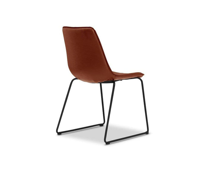 The Oken Dining Chair is a modern, minimalist dining chair with a cushioned seat and backrest, shown on a white background and featuring slender black metal sled legs.