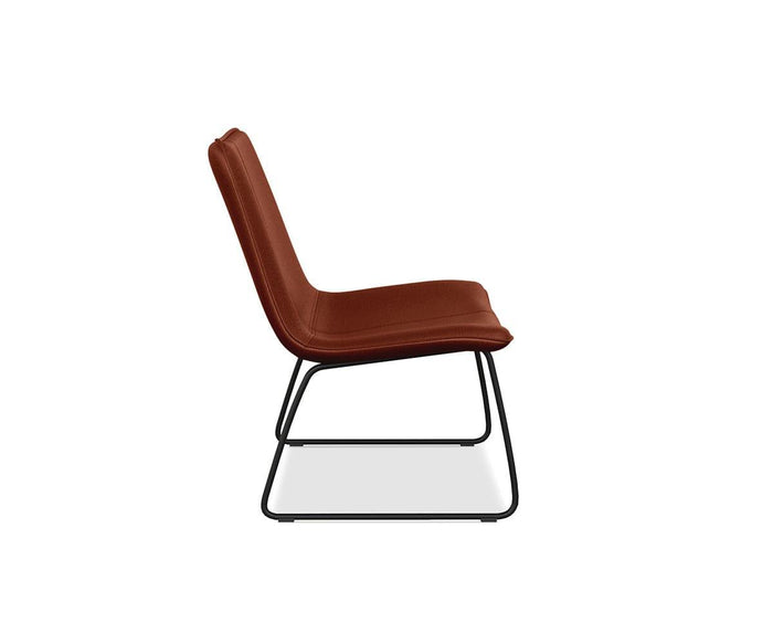Side view of the Oken Lounge Chair, featuring comfortable burnt orange upholstery and a modern black metal sled base, set against a plain white background.