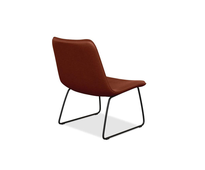 The Oken Lounge Chair features a modern, curved design with a reddish-brown upholstered seat and backrest for comfortable seating. It is supported by slender black metal sled legs and is displayed against a plain white background, angled slightly to the left.