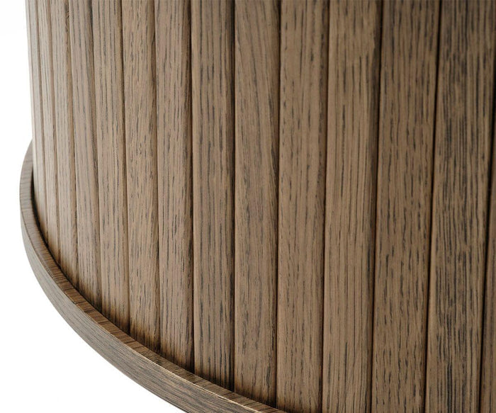 Close-up of the Orella Round Coffee Table’s curved wooden surface with vertical slats and a smoothly rounded base edge, highlighting the natural wood grain and textured tambour paneling—an elegant detail characteristic of modern living room furniture.