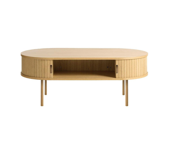 The Orella Storage Coffee Table features an oval shape crafted from light wood, vertical tambour-inspired grooves, an open central shelf for storage, and four slim legs. Its minimal and modern design makes it a perfect centerpiece for a contemporary living room.