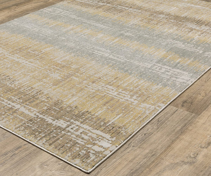 The Oriental Weaver Mallory / MAL06 Rug is a modern power-loomed design featuring a textured, organic pattern in muted yellow, gray, and cream tones made from space dyed polypropylene, shown here on a light wood floor.