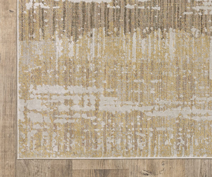 A close-up of the Oriental Weaver Mallory / MAL06 Rug, featuring an abstract organic pattern in gold, beige, and white tones, power-loomed from space dyed polypropylene and displayed on a light brown, natural-finish wooden floor.