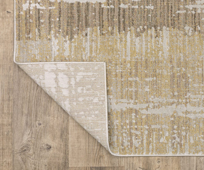 An Oriental Weaver Mallory / MAL06 Rug, crafted from space dyed polypropylene and featuring an organic pattern in beige, yellow, and gray tones, lies on a wood floor. One corner of this textured power-loomed rug is folded over to reveal the lighter underside and detailed stitching along the edge, adding visual interest to any space.