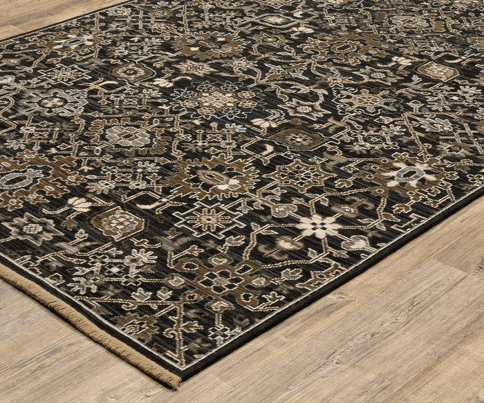 The Oriental Weavers Acacia / ACA05 Rug, expertly crafted using an Axminster loom, features a detailed floral and geometric pattern in shades of black, beige, and brown, beautifully placed on a light wood floor.