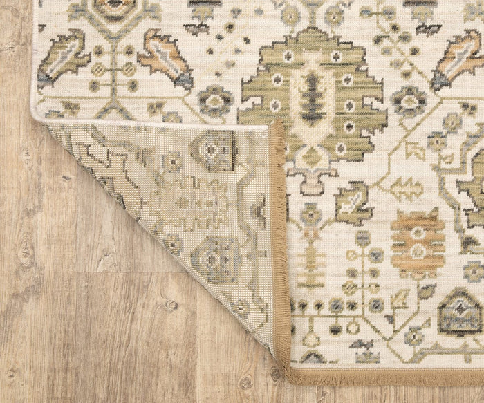 The Oriental Weavers Acacia / ACA11 Rug, featuring beige and green hues with geometric and floral motifs, is laid on a light wooden floor with one corner flipped to reveal its underside.