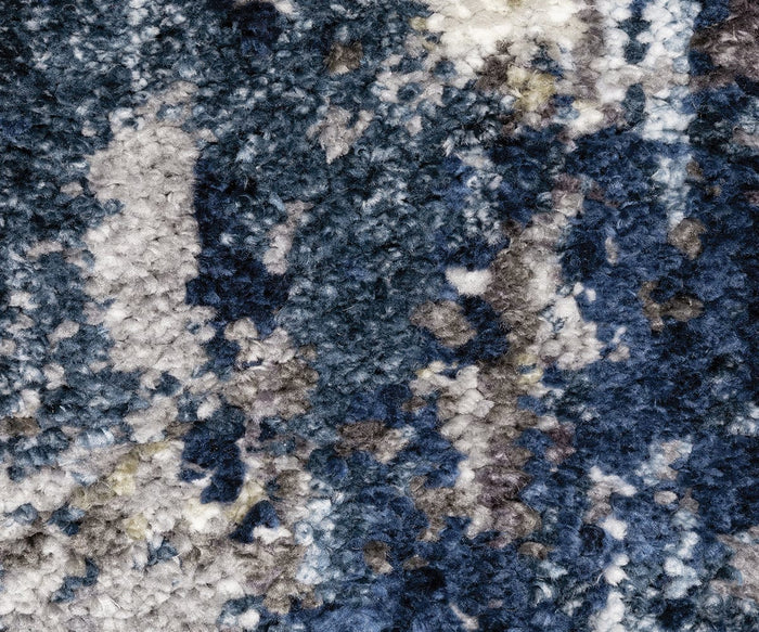 Close-up of the Oriental Weavers Aspen / 2061L Rug, featuring space-dyed microfiber polyester fibers in a blend of blue, white, gray, and black, which create a mottled and abstract rug pattern.
