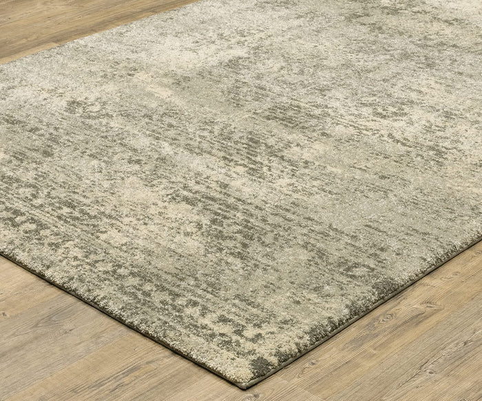 The Oriental Weavers Astor / 1806Q Rug, featuring a plush pile and a modern abstract design with subtle color variations and vintage-inspired motifs in mottled gray and beige, sits on a light wood floor.