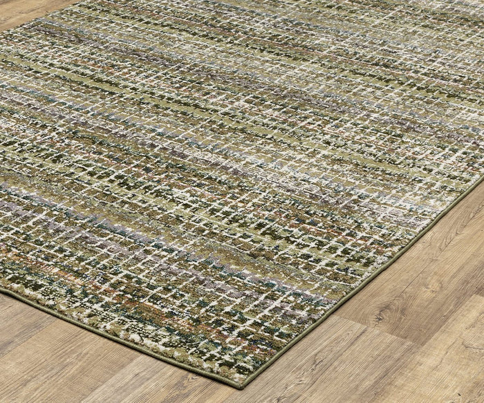 The Oriental Weavers Atlas / 747A Rug, a rectangular area rug from the Atlas Collection, showcases an abstract grid pattern in green, white, brown, and gray tones and is displayed on a light wood floor. This durable machine-woven rug is ideal for high-traffic areas.
