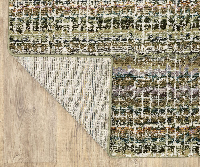 A close-up of the Oriental Weavers Atlas / 747A Rug showcases its vibrant multicolored pattern, with one corner turned over to display the underside. Machine-woven and situated on a light wood floor, this rug from the Atlas Collection is a stylish and durable choice for high-traffic areas.