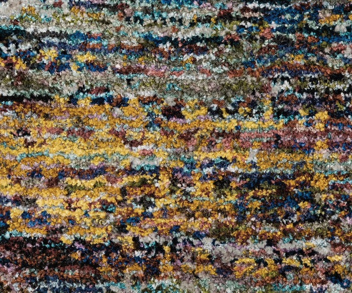 Close-up of the Oriental Weavers Atlas / 8037B Rug, showcasing a multicolored, textured surface with yellow, brown, blue, green, and purple threads in an abstract mottled design. This machine-woven carpet from the Atlas Collection combines contemporary style with the dependable durability characteristic of a high-quality area rug.