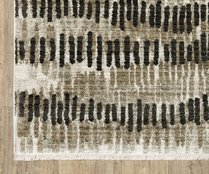 A section of the Oriental Weavers Bauer / 8120D Rug is shown, featuring vertical black and brown brushstroke patterns on a beige background, placed on a wooden floor. Crafted from recycled PET yarn, this sustainable rug includes a fringed edge and is easy to clean for everyday convenience.