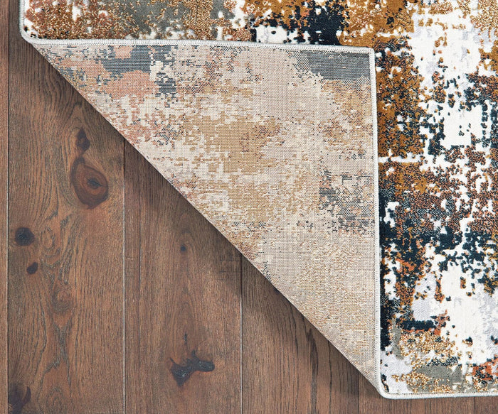 An Oriental Weavers Bowen / 4928X Rug, showcasing an abstract pattern in beige, white, orange, and dark blue, lies on wooden flooring with one corner folded over to display the backing. This modern rug from the Bowen Collection is machine-woven and features a contemporary textured design.