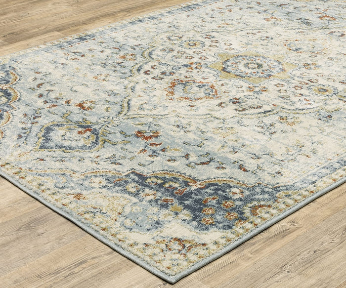 An Oriental Weavers Branson / BR01A Rug, featuring an intricate, faded floral and geometric pattern with modern motifs in blue and cream hues, is power-loomed and set on a light wooden floor.