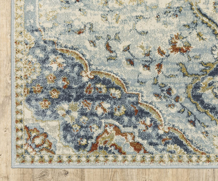 A close-up of the Oriental Weavers Branson / BR01A Rug, featuring a blue, cream, and rust-colored pattern with a vintage look, placed on a light wood floor. This power-loomed rug showcases intricate abstract floral and vine designs blended with modern motifs.