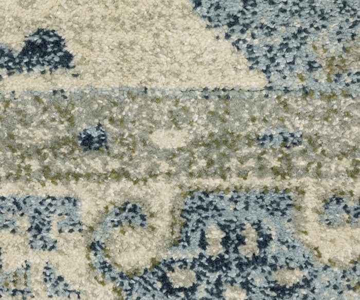 Close-up of the Oriental Weavers Branson / BR03A Rug showcases its textured, power-loomed construction and abstract pattern in blue, cream, and light green tones. The soft, dense fibers create a plush surface with modern-inspired shapes and subtle color variations.