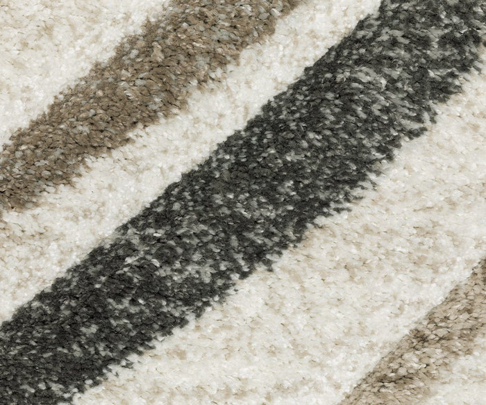 Close-up of the Oriental Weavers Cambria / 162W Rug, showcasing its textured high-pile surface with diagonal stripes in gray, beige, and off-white tones. Woven from soft polypropylene yarn, this plush rug adds a cozy and inviting touch to any space.