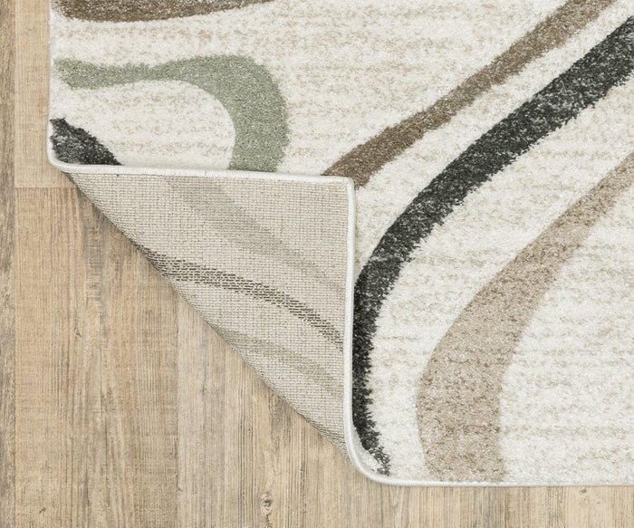A corner of the Oriental Weavers Cambria / 162W Rug is folded over on a light wood floor, revealing the backing. This high-pile rug features curved lines in beige, green, and black on a cream background, all crafted from durable polypropylene yarn.