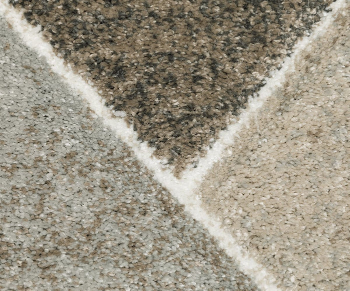 Close-up of an Oriental Weavers Cambria / 4L Rug featuring a geometric pattern in shades of beige, brown, and gray, highlighted by a white intersecting line. Made from soft polypropylene yarn, this high-pile rug offers both comfort and modern style to any space.