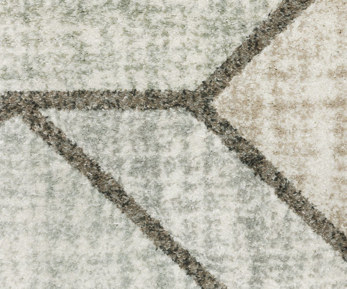 Close-up of the Oriental Weavers Cambria / 5569B Rug, featuring a textured high-pile surface with an abstract geometric pattern in shades of gray, cream, and beige, highlighted by intersecting lines and shapes and crafted from durable polypropylene yarn.