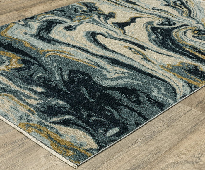 The Oriental Weavers Capella / CAP10 Rug, featuring a rectangular shape and a marbled design in blue, cream, and gold hues with space-dyed polyester construction, is shown placed on a light wood floor.