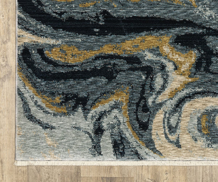 Corner of the Oriental Weavers Capella / CAP10 Rug, featuring swirling abstract patterns in black, gold, gray, and cream hues. Crafted from space-dyed polyester, this textured area rug lies atop a light wood floor, with visible fringes along its edge.