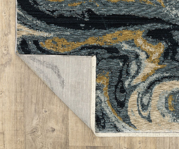 A close-up of the Oriental Weavers Capella / CAP10 Rug highlights its modern geometric patterns in swirling black, gray, yellow, and cream tones atop a wooden floor. Made from space-dyed polyester, one corner is lifted to reveal the rug’s light gray backing.