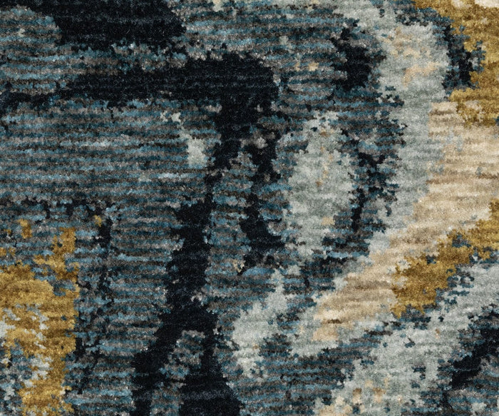 Close-up of the Oriental Weavers Capella / CAP10 Rug, featuring a textured surface crafted with space-dyed polyester. This rug showcases abstract patterns in blue, black, gray, and gold, blending irregular organic shapes with subtle geometric accents and varying color intensity throughout.