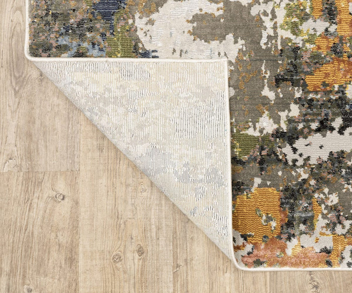 A corner of the Oriental Weavers Caravan / 502X Rug is flipped over on a light wood floor, revealing its underside and detailed edge stitching. The space-dyed polyester fibers feature a nature-inspired pattern that brings vibrant character to any room.