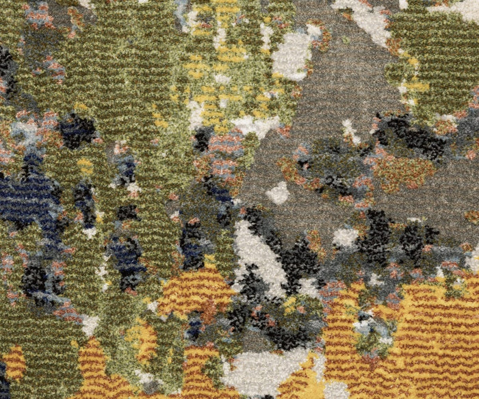 Close-up of the Oriental Weavers Caravan / 502X Rug featuring a multicolored textured surface with abstract patches of yellow, green, blue, gray, and orange. The space-dyed polyester fibers form a vibrant, nature-inspired pattern reminiscent of a patterned carpet or fabric weave from the Caravan Collection.