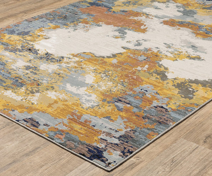 The Oriental Weavers Caravan / 530V Rug showcases a painterly, nature-inspired pattern in a blend of yellow, orange, blue, gray, and white hues. Placed on a light wood floor, this area rug is crafted from space-dyed polyester and features a modern artistic design with soft, blended edges.